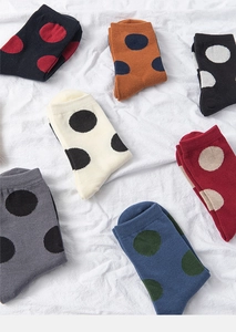 Flat lay detail showing seven pairs of colorful polka dot pattern cotton blend socks