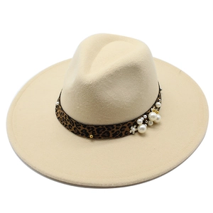 Detail of beige wool fedora featuring leopard print band with pearls and floral charms