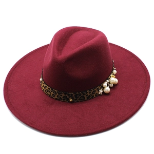 Detail of burgundy wool fedora featuring leopard print band with pearls and floral accents