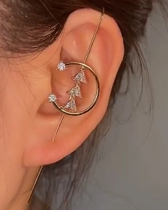 Detail of gold ear crawler with sparkling zircons worn by a model in a side-profile view