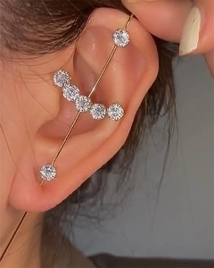 Macro view of gold ear crawler featuring seven shimmering zircons along the earlobe