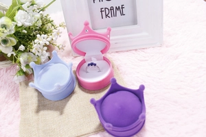 Three crown-shaped velvet jewelry boxes in pink, blue and purple colors