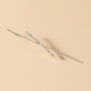 Macro shot of silver minimalist ear cuff with small white zircon stones on a beige background