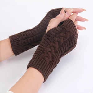 Detail of dark brown cable-knit fingerless gloves showing texture and material on hand