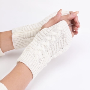 Detail of cream-colored chunky cable knit fingerless gloves showing warm wrist textures