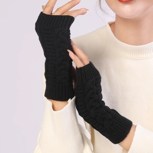 Detailed close-up of black cable knit fingerless gloves showing thick woolen texture