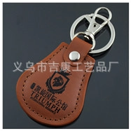 Detail of custom brown leather keychain with silver metal ring and embossed logo