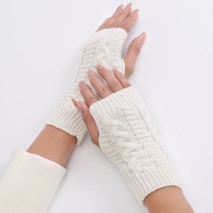 Detail of cream cable knit fingerless gloves showing soft texture and twisted pattern
