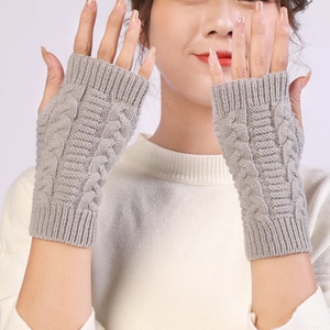 Detailed view of cable knit pattern and ribbed cuff on light grey fingerless gloves