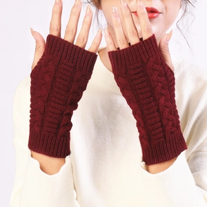 Close-up of wine red cable knit fingerless gloves showing warm textured wool detail
