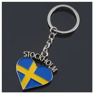 Detail of a heart-shaped metal keychain with Stockholm Sweden flag design in blue and gold