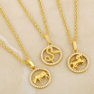 Detailansicht der goldenen Tierkreis-Halsketten mit Strass auf Marmorhintergrund