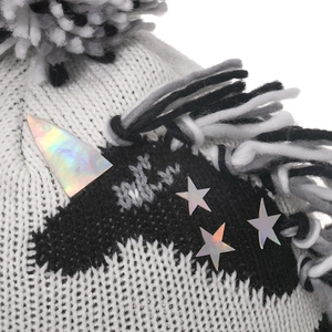Détail du bonnet licorne avec corne holographique et pompon noir et blanc doux