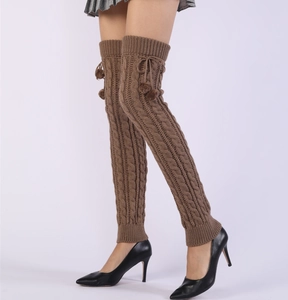 Detail of 65cm thick cable knit over-knee leg warmers with pompom drawstring detail