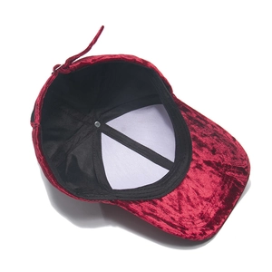 Detail of red velvet baseball cap showing inner lining and adjustable metal buckle