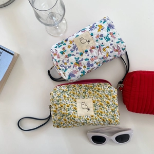 Tre beauty case in cotone trapuntato con motivi floreali e rosso con manico laterale