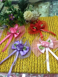 Close-up of handmade ribbon flowers with pearls and bows in pink and red colors