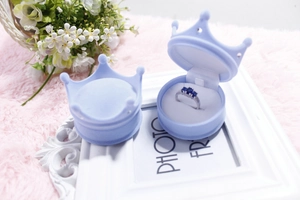 Macro detail of crown shaped light blue velvet ring box with plush interior base