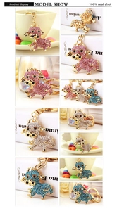 Dettaglio di simpatici portachiavi a mucca con strass colorati in rosa, blu, bianco e oro