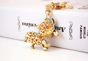 Dettaglio portachiavi a forma di mucca dorata con cuori traforati e strass blu