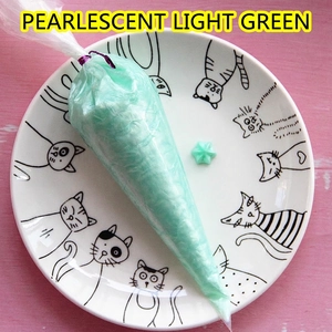 Pearlescent light green cream glue in a piping bag with a star-shaped sample on a plate