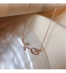 Detail of rose gold tulip necklace with white shell inlay and zircon leaf accents