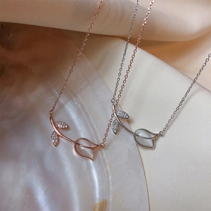 Elegant tulip flower opal necklaces in rose gold and silver finishes on a pearl shell