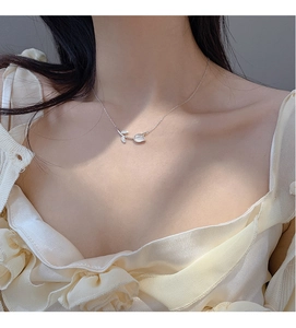 Silver flower necklace with white opal tulip pendant worn on neck for fashion display