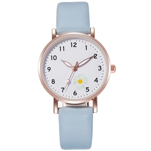 Dettaglio della cassa dell'orologio oro rosa con cinturino in pelle azzurra e margherita