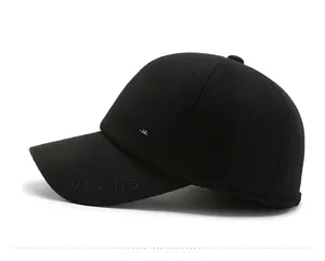 Close-up of black wool baseball cap featuring JEANS metal badge and embossed detail