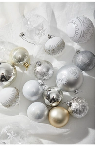 Detail of elegant silver and champagne Christmas ornaments on white textured fabric