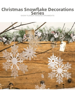 Close-up of sparkling white and gold snowflake ornaments hanging on rustic tree branches