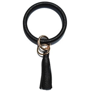 Close-up of black pebble leather keychain bangle with fringe tassel and gold hardware