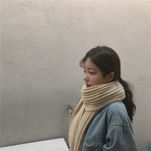 Detail of thick beige knit scarf showing soft chunky texture and warm wool-like material