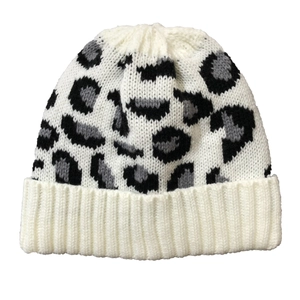 Detailed view of white leopard print knit beanie with ribbed cuff and soft wool texture
