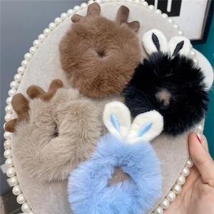 Plush hair scrunchies with cute bunny ears and reindeer antlers on an elegant tray