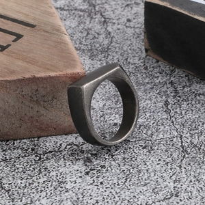 Close-up of minimalist industrial style titanium steel square ring with a distressed gray finish