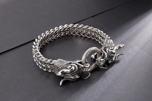 Macro shot of double dragon head clasp on vintage silver steel braided bracelet