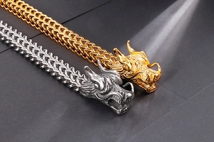 Close-up of gold and silver double dragon head bracelets with thick woven steel chain