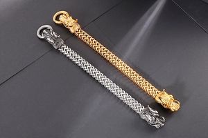 Detailed close-up of woven stainless steel dragon bracelets in gold and antique silver finish