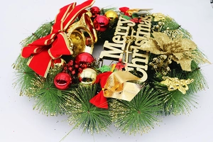 Détail d'une couronne de Noël de 40cm avec nœud rouge, cloches dorées et signe Joyeux Noël