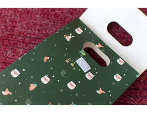 Macro detail of green Christmas gift bag with festive patterns and velcro closure