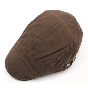 Dettaglio cappello piatto marrone in cotone con cuciture e fibbia in metallo dorato
