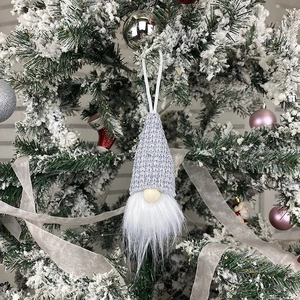 Handmade Christmas gnome plush pendant with grey knitted hat on snowy pine branch