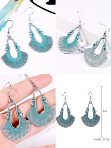 Detail of vintage bohemian fan-shaped earrings with patina finish and size markings