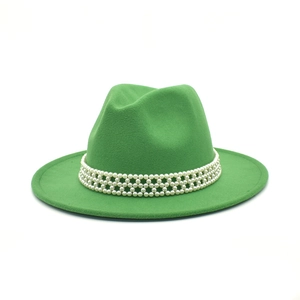 Detail of a bright green fedora hat featuring a white pearl woven band on wool felt fabric