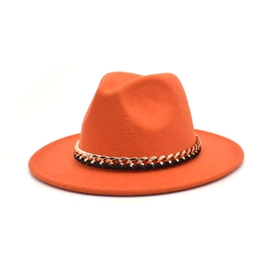 Detail of orange wool fedora featuring a chunky gold chain with black woven strap