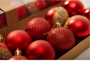 Detail of red Christmas baubles with matte, glitter and painted textures in a gift box