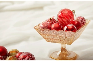Red and gold Christmas ball ornaments in vintage amber glass tray with festive silk decor