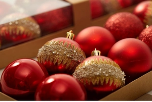 Close-up of red and gold Christmas ornaments with matte, glossy, and glitter finishes